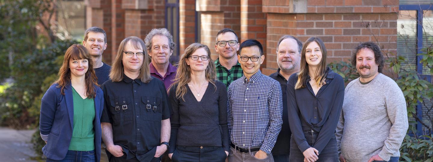 Ten people smile for the camera.