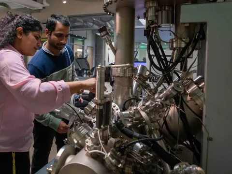 two students examine an XPS machine