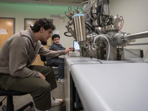 Two students operate a ToF-SIMS instrument